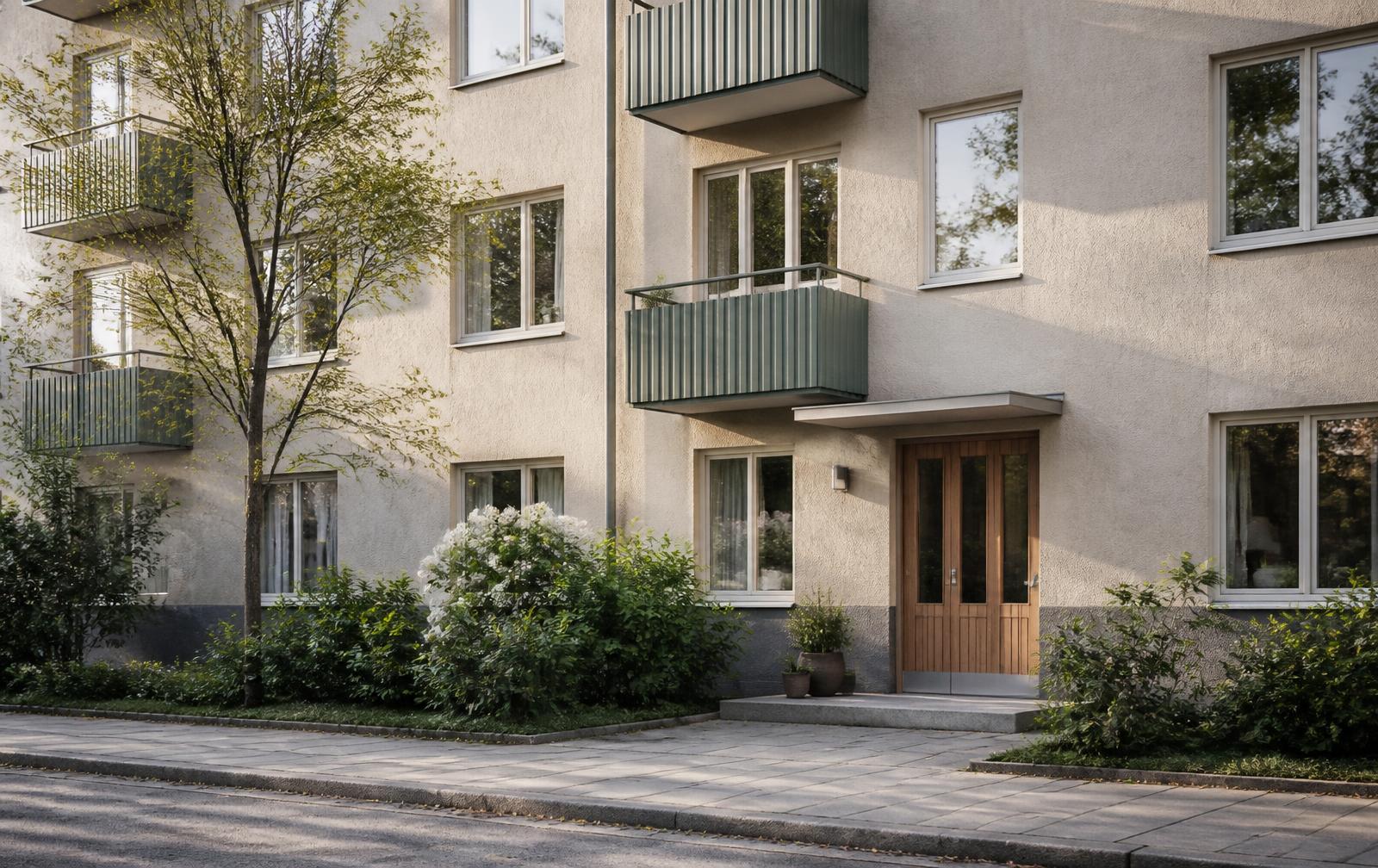 Fasad på ett svenskt flerbostadshus med entré och grönska